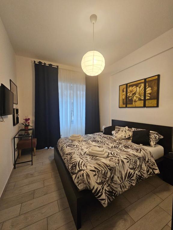 een slaapkamer met een groot bed en een hanglamp bij La Dolce Vita apartment in Rome in Rome