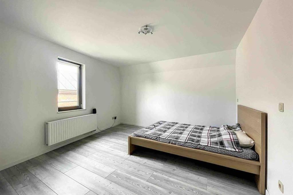 Cette chambre blanche dispose d'un lit et d'une fenêtre. dans l'établissement Charleville 39 I Bruxelles-charleroi-aéroport, à Charleroi
