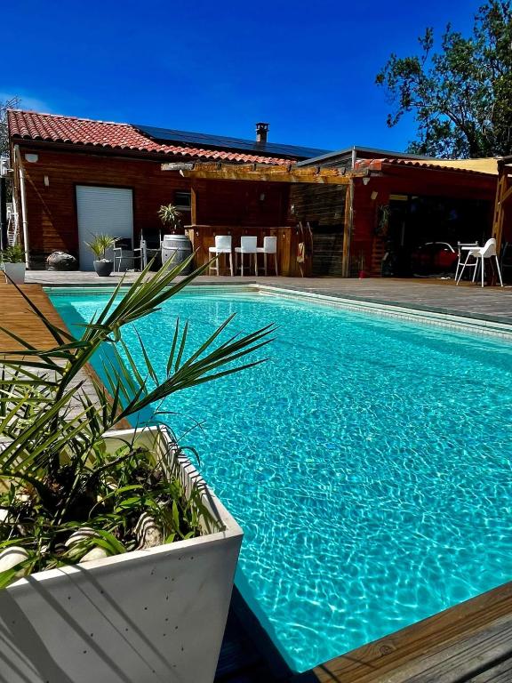 uma piscina em frente a uma casa em Ma maison en bois avec Jacuzzi em Lavelanet