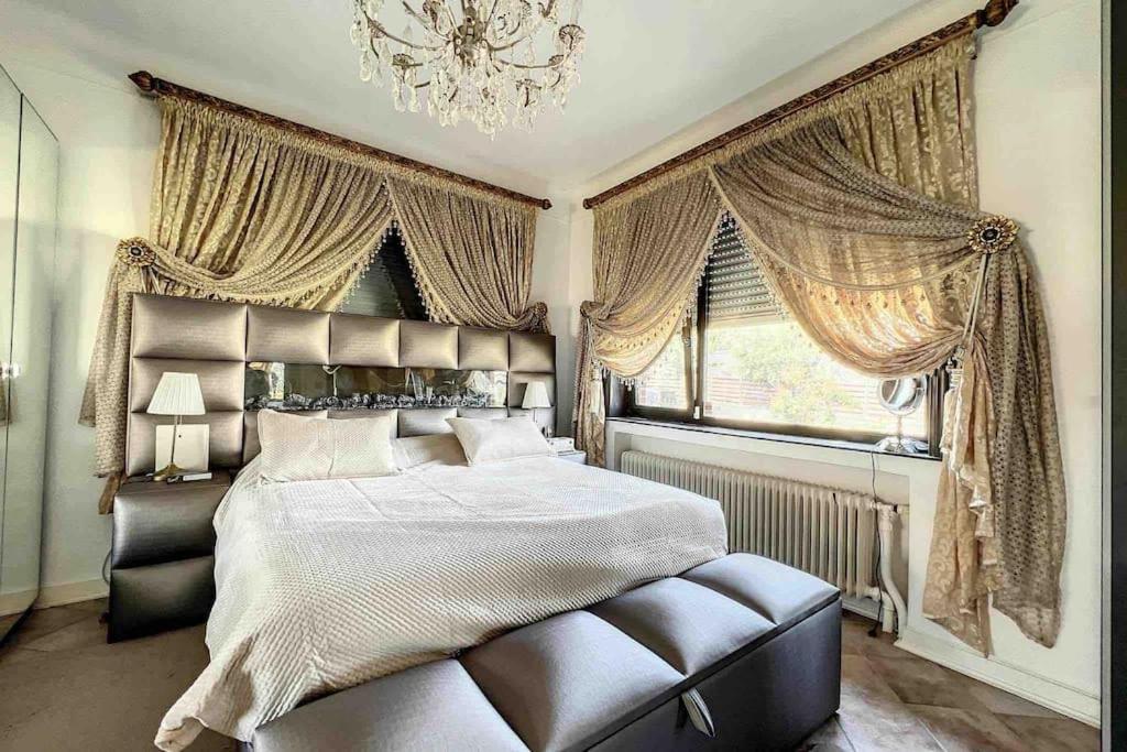 sypialnia z dużym łóżkiem i żyrandolem w obiekcie Charleville 39 L Bruxelles-charleroi-aéroport w Charleroi