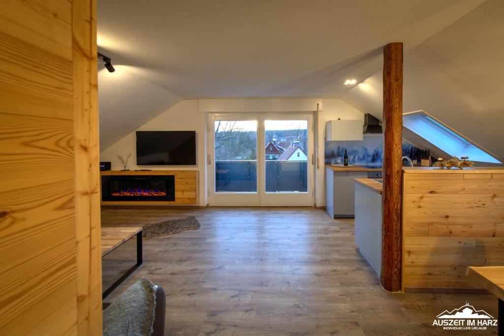 een keuken en een woonkamer met een open haard in een huis bij Auszeit-im-Harz Haus 3 Wohnung 8 in Braunlage