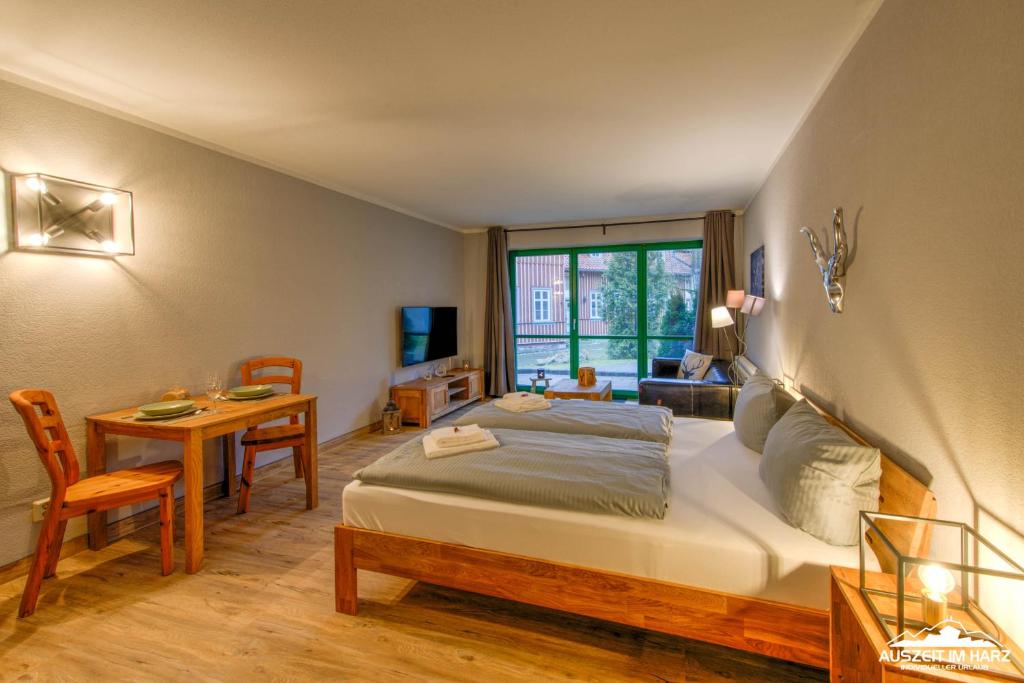 um quarto com uma cama, uma secretária e uma mesa em Auszeit-im-Harz Haus 5 Wohnung 11 em Stiege