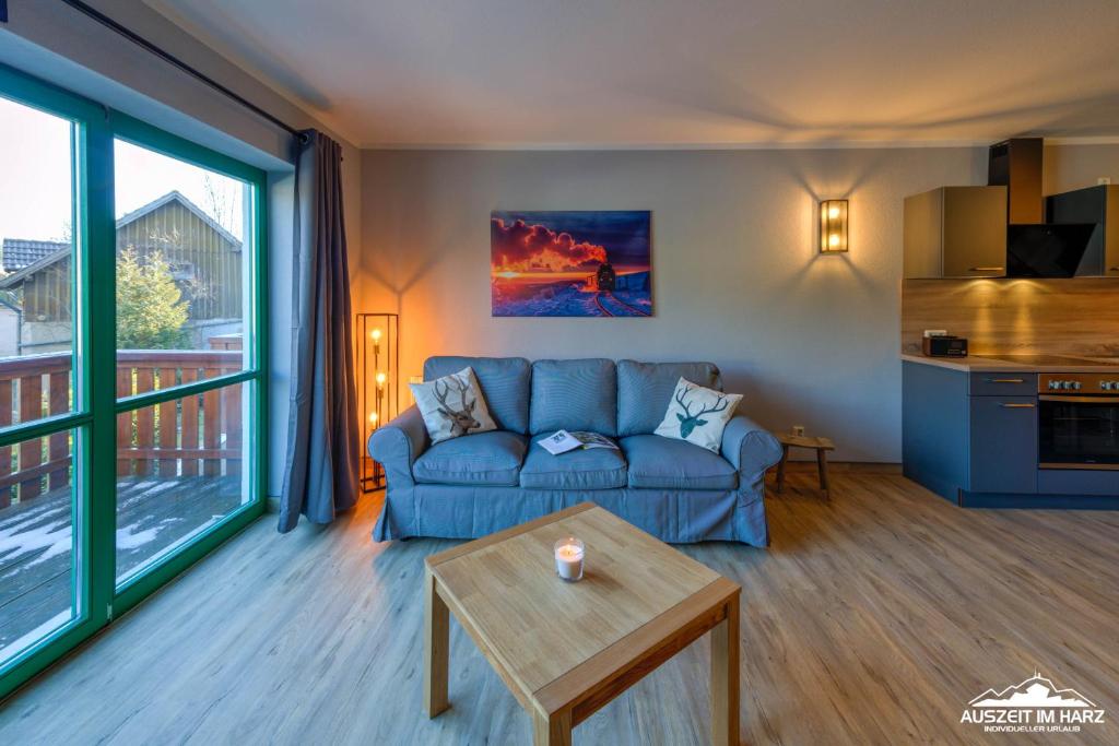 a living room with a blue couch and a table at Auszeit-im-Harz Haus 5 Wohnung 23 in Stiege