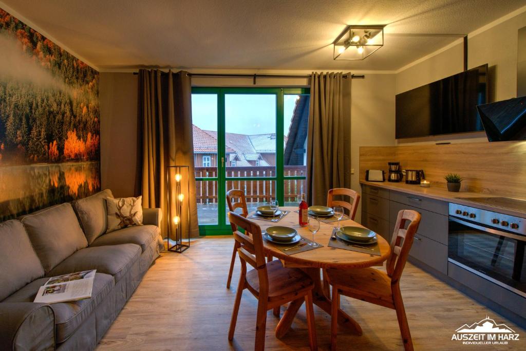 una sala de estar con una mesa y un sofá en Auszeit-im-Harz Haus 5 Wohnung 35, en Stiege