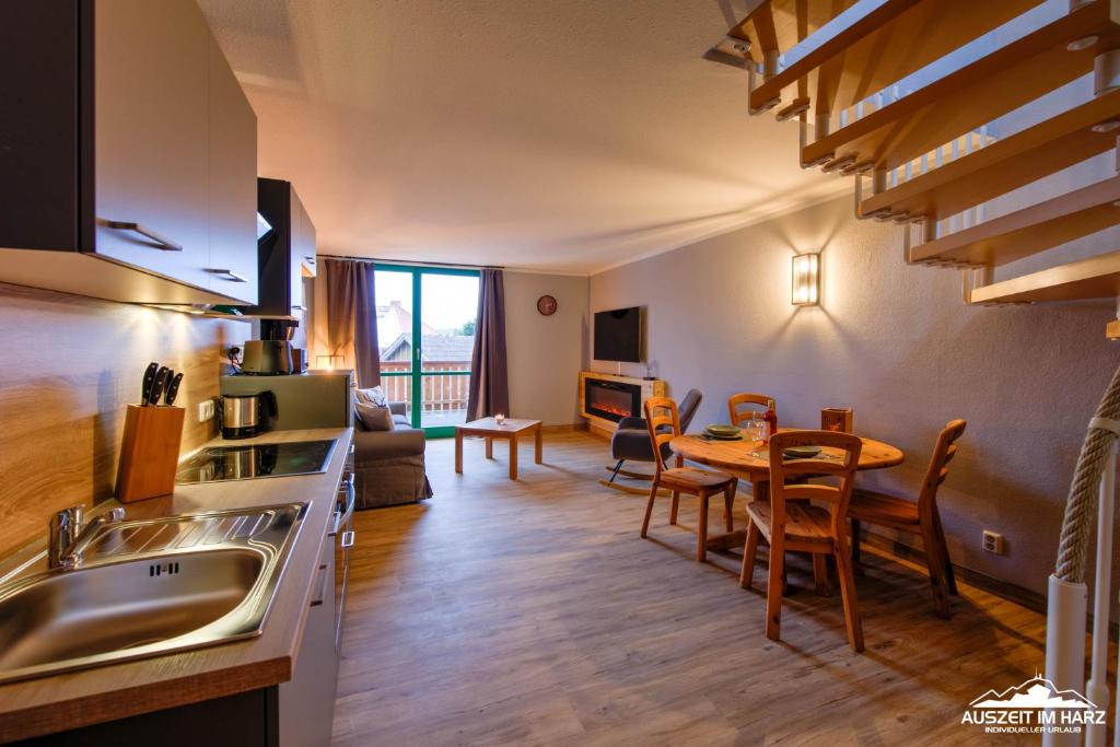 a kitchen and living room with a table and a dining room at Auszeit-im-Harz Haus 5 Wohnung 37 in Stiege