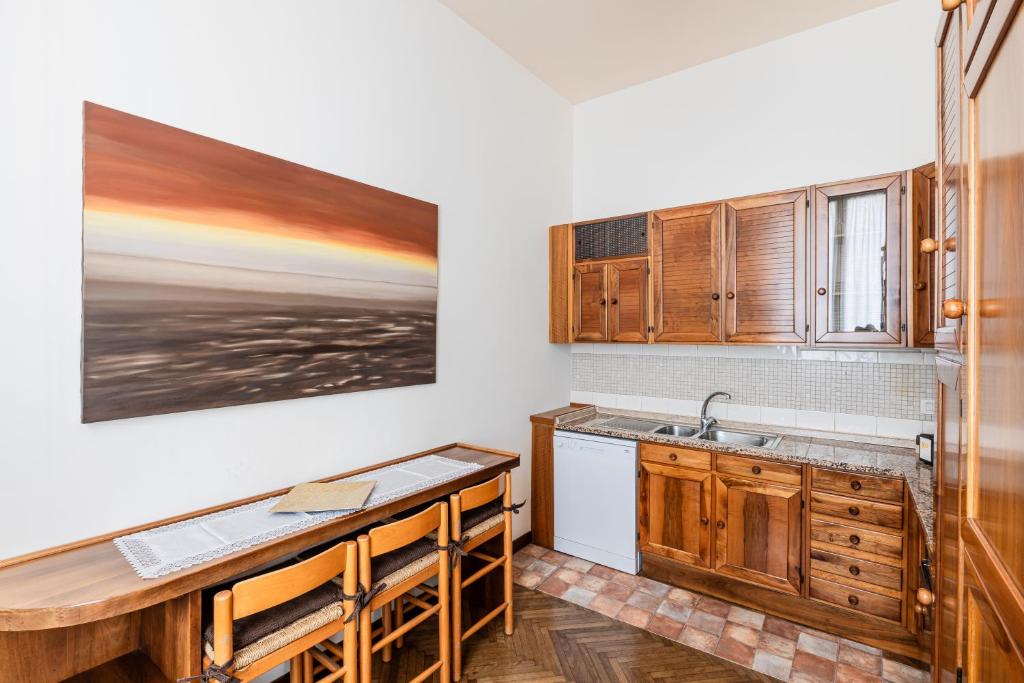 a kitchen with wooden cabinets and a sink at Molinari House Lux - Appartamento Elegante in Centro Modena - Free ZTL in Modena