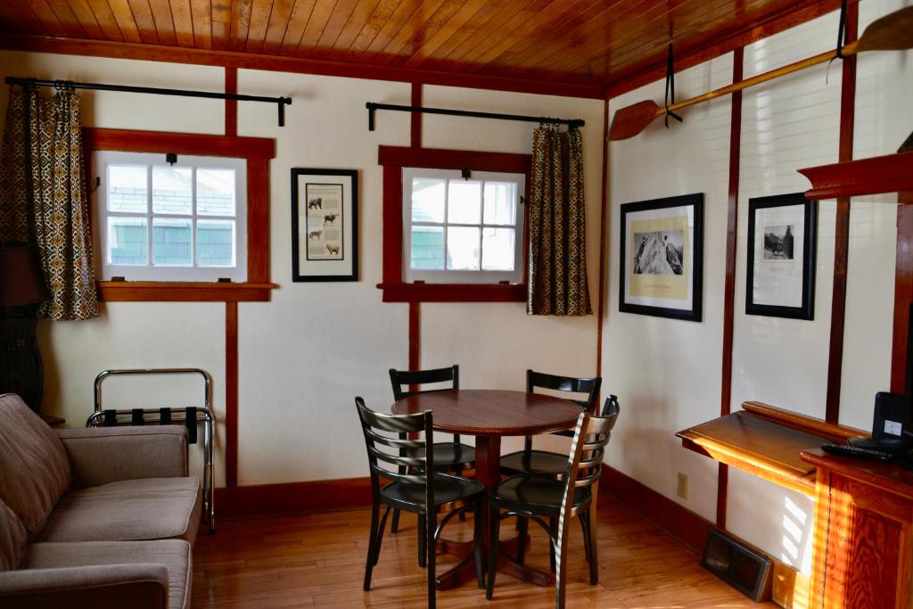 - un salon avec une table, des chaises et un canapé dans l'établissement Banff Beaver Cabins, à Banff
