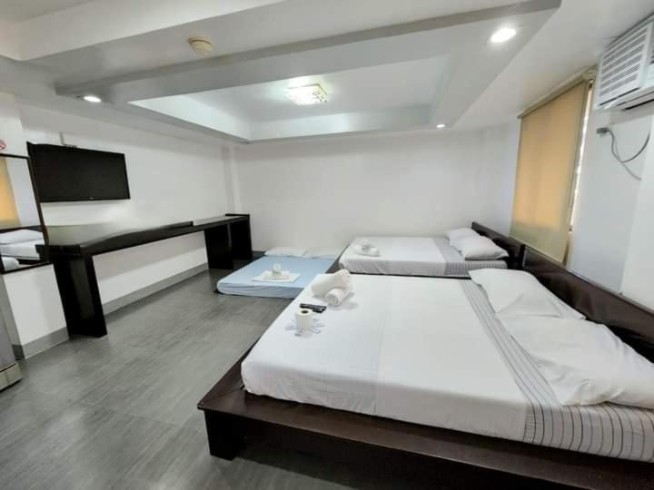 duża sypialnia z 2 łóżkami i biurkiem w obiekcie MGG CASA DELA PLAYA w mieście Boracay
