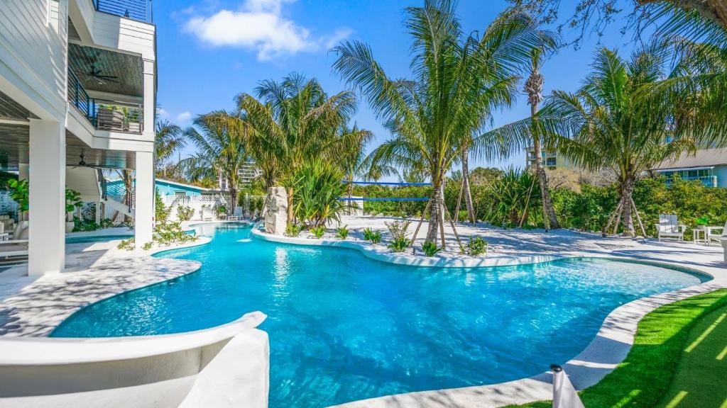 a swimming pool in a resort with palm trees at Shaker of Salt in Siesta Key
