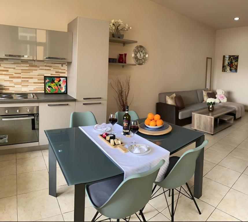 cocina y sala de estar con mesa y sillas en Sliema Aqualuna Premium Apartment en Sliema