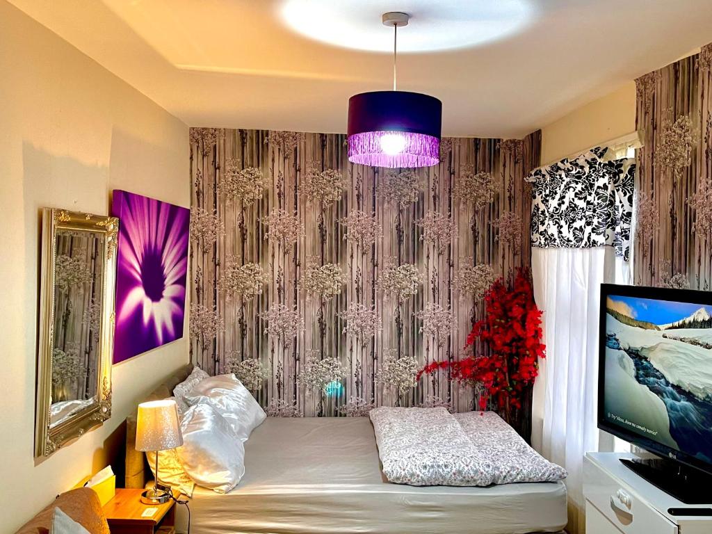 a bedroom with a bed and a purple curtain at Comfy Double bedroom with a Private Toilet in London