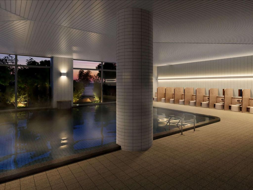 una piscina en un edificio con sillas alrededor en Mercure Wakayama Kushimoto Resort & Spa, en Kushimoto