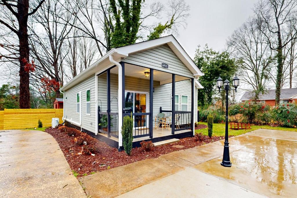 een klein wit tiny house met een veranda bij The Pool House in Charlotte
