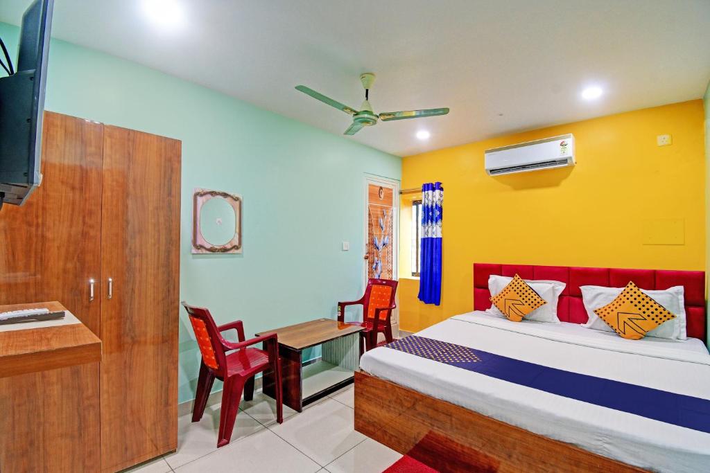 BhadrakにあるSPOT ON Mahaveer Resortのベッドルーム1室(ベッド1台、デスク、テーブル付)