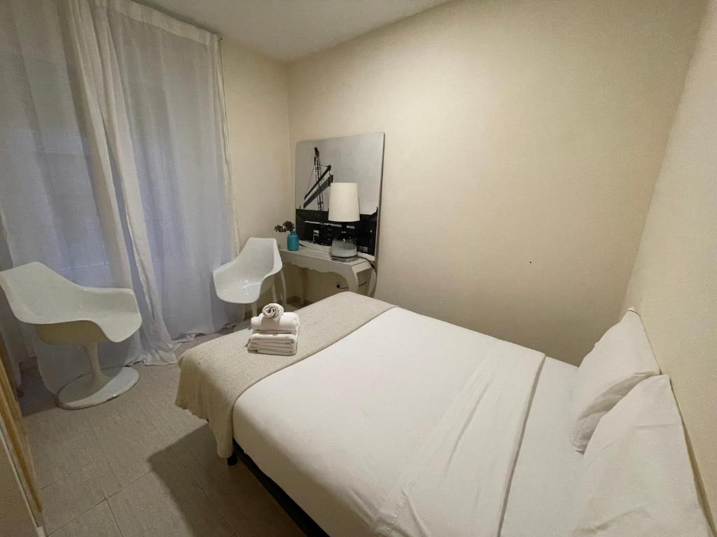 1 dormitorio con cama, silla y escritorio en casa huéspedes tadeo gran via, en Madrid