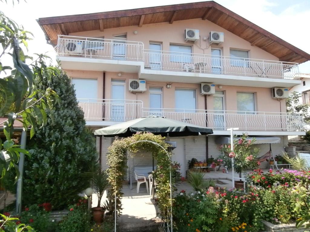 バルチクにあるVilla Karinaの傘と庭園付きのアパートメントビル