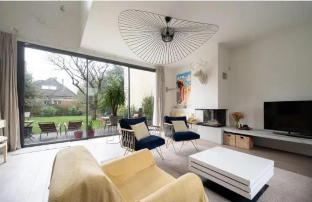 un salon avec un canapé et des chaises et une grande fenêtre dans l'établissement Parc Saint James, à Neuilly-sur-Seine