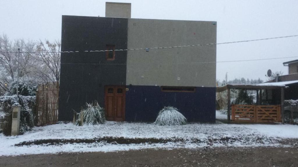 un edificio con nieve en el suelo delante de él en La Delia en Villa Rumipal