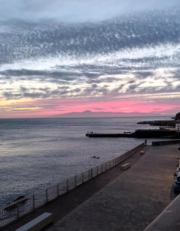 a view of the ocean at sunset with a pier at Oasis Noalys in Sardina