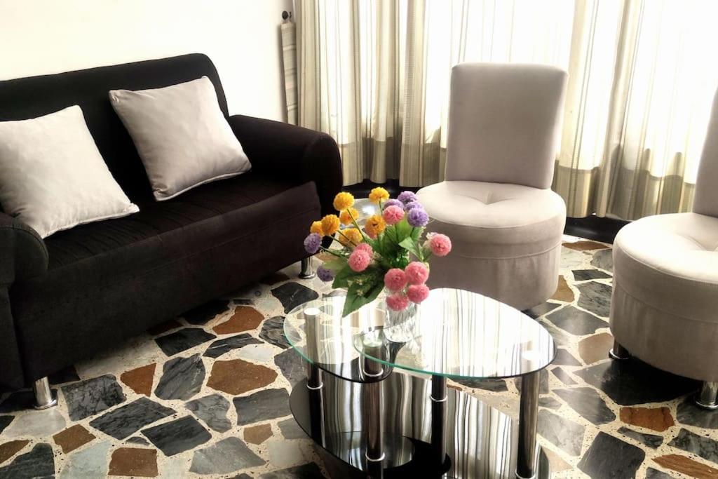 un salon avec un canapé et une table en verre dans l'établissement Comodo apartamento en Pereira, à Pereira