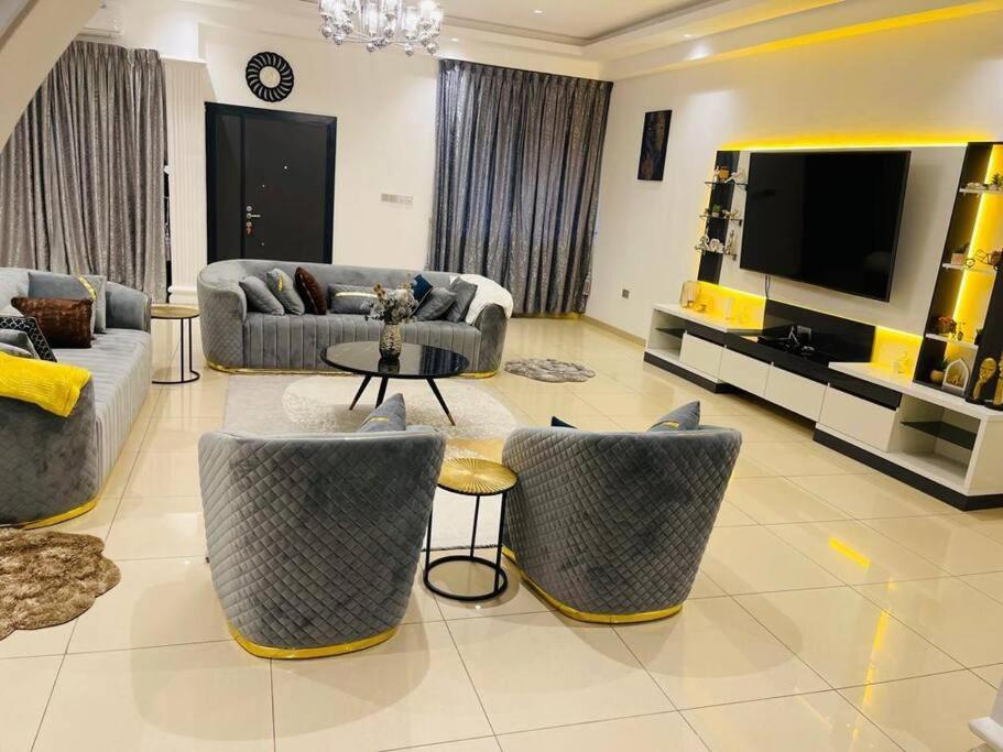 ein Wohnzimmer mit Sofas und einem Flachbild-TV in der Unterkunft Executive Home away from Home in Accra