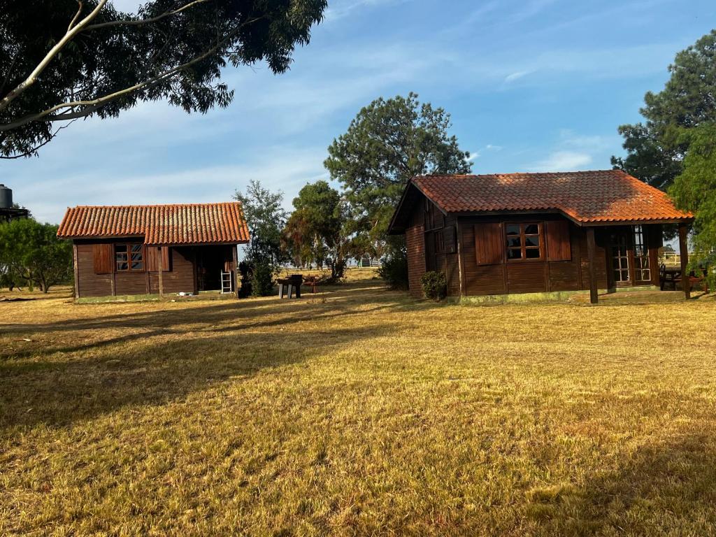 an old house and a barn in a field at Cabañas en Parque Aqua Park in Juan L. Lacaze