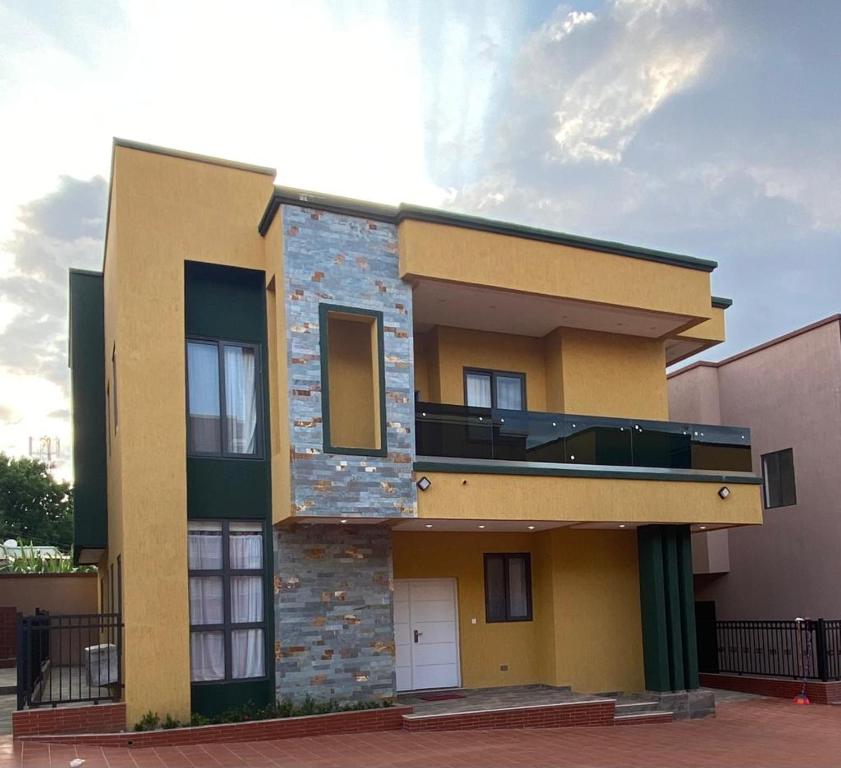 - un bâtiment avec un balcon sur le côté dans l'établissement Cozy Lux Apartments by Harolty, à Kumasi
