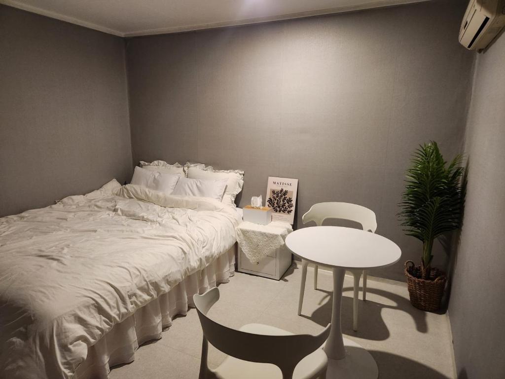 una camera con letto, tavolo e sedie di Stay Mido a Busan