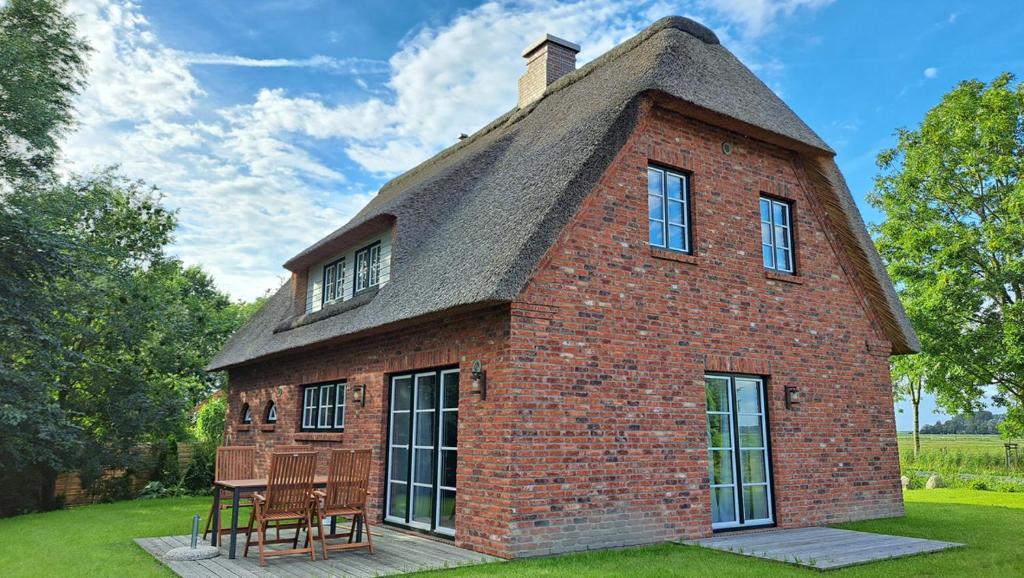 een klein bakstenen huis met een rieten dak bij Möwen-Nest in Tönning