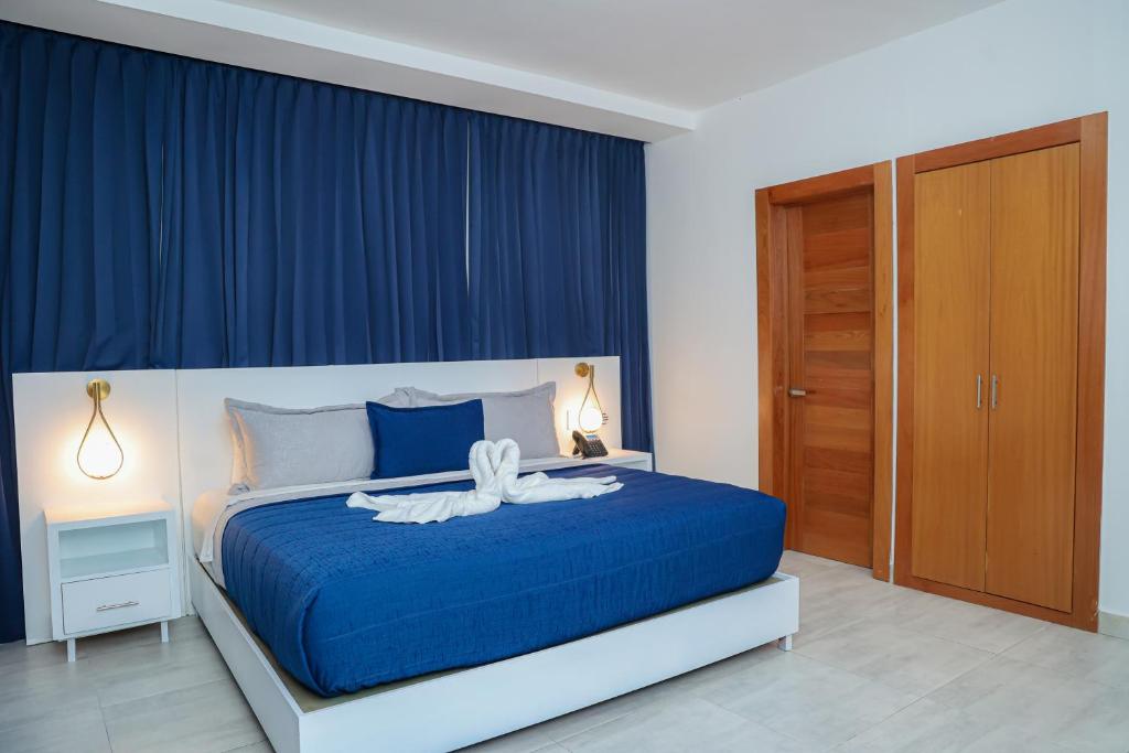 a bedroom with a blue bed and blue curtains at JOMYS HOTEL en Higüey in Higuey
