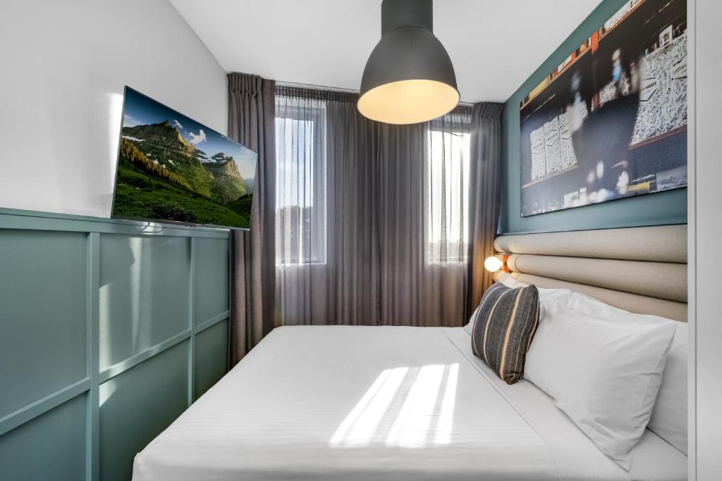 a bedroom with a bed and a flat screen tv at The Urban Newtown in Sydney