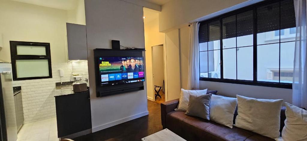 a living room with a couch and a flat screen tv at Baireshistorico in Buenos Aires