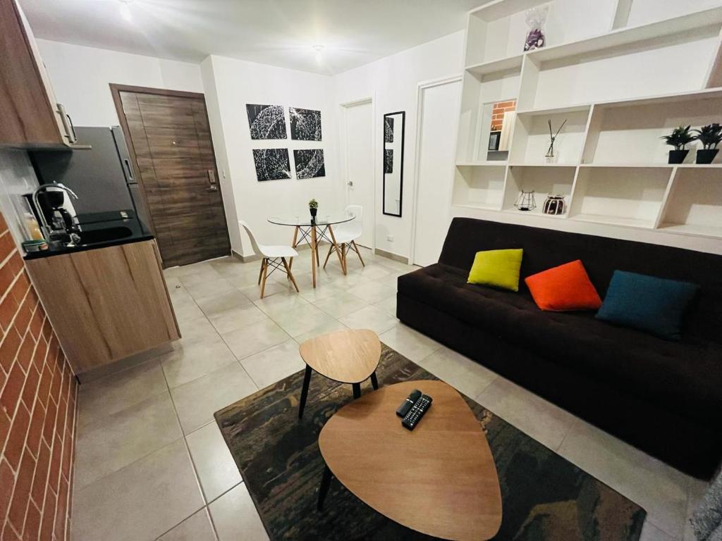 a living room with a black couch and a table at Apartamento zona 4, Ciudad de Guatemala in Guatemala