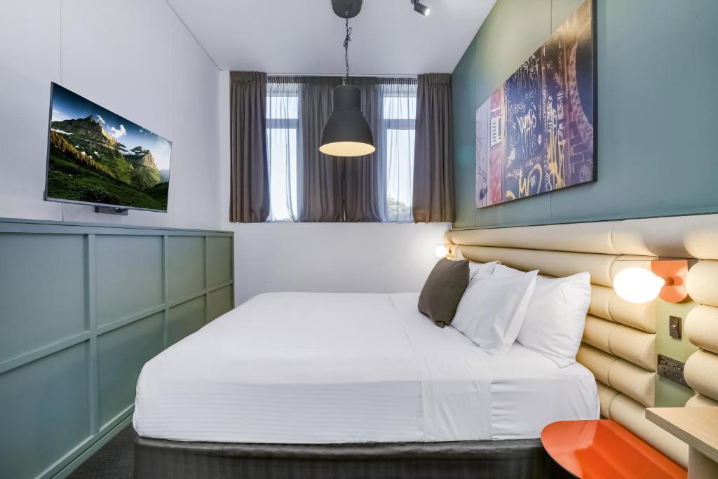 a bedroom with a bed and a tv at The Urban Newtown in Sydney