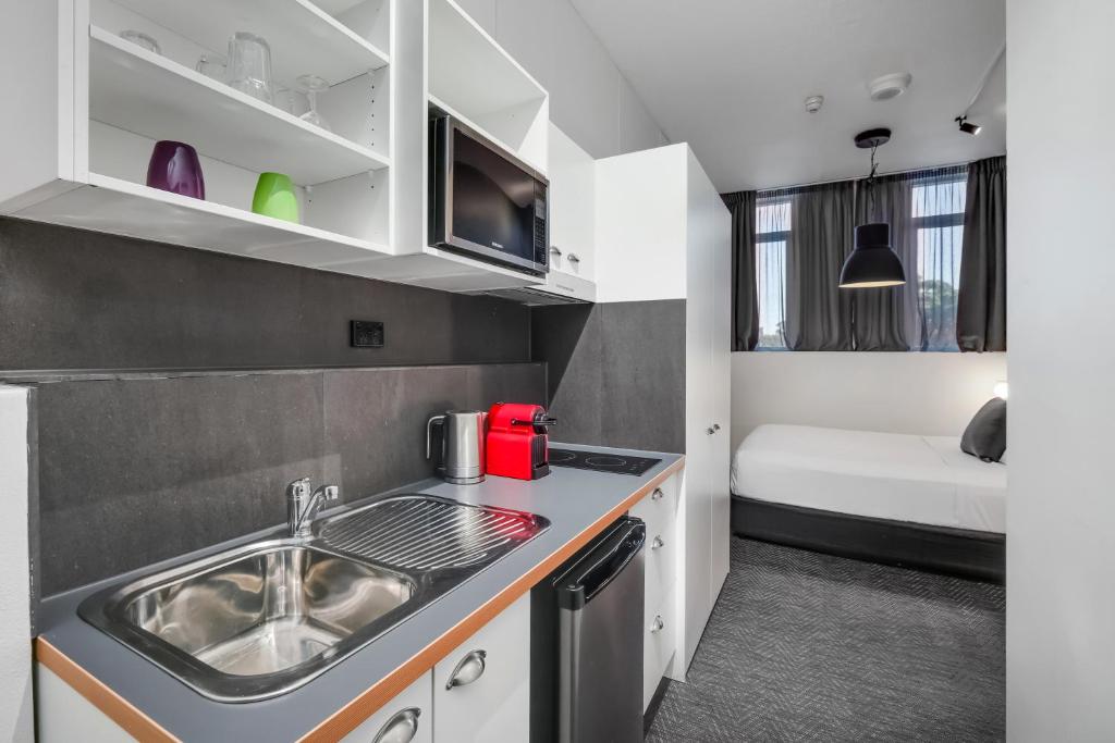 a small kitchen with a sink and a tub at The Urban Newtown in Sydney