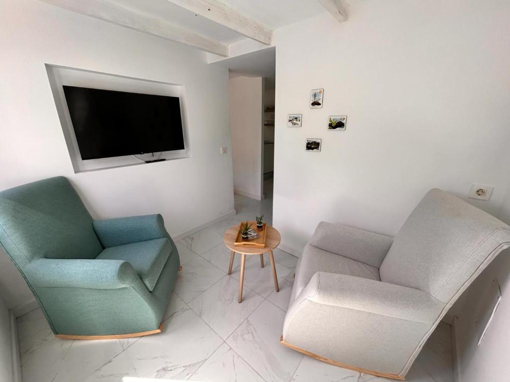 a living room with two chairs and a tv at CASA ELEO in Arrecife