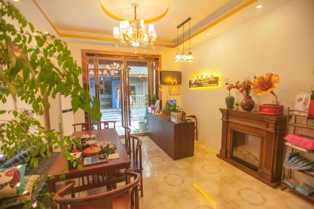 - un salon avec une table et une cheminée dans l'établissement Zhangjiajie Tianmen Mountain Aribadi Inn, à Zhangjiajie