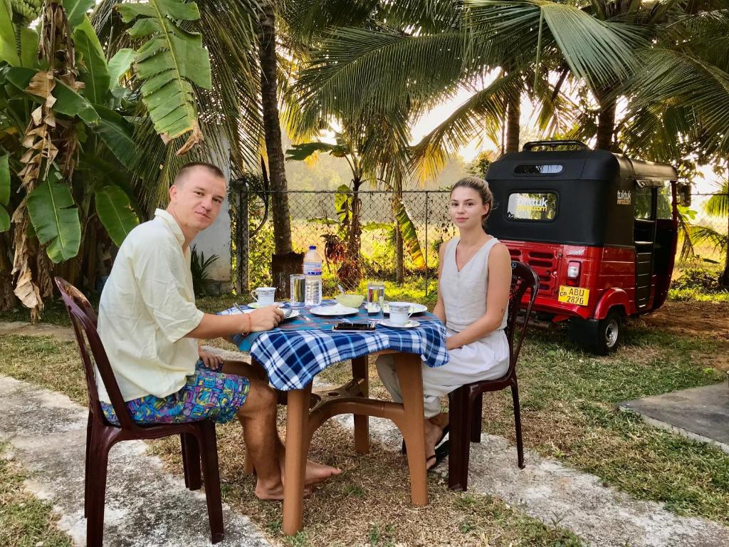 un hombre y una mujer sentados en una mesa en Yapahuwa Oasis en Maho
