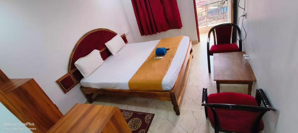 a bedroom with a bed and a desk and a chair at SRIKRUTI SEA VIEW in Puri