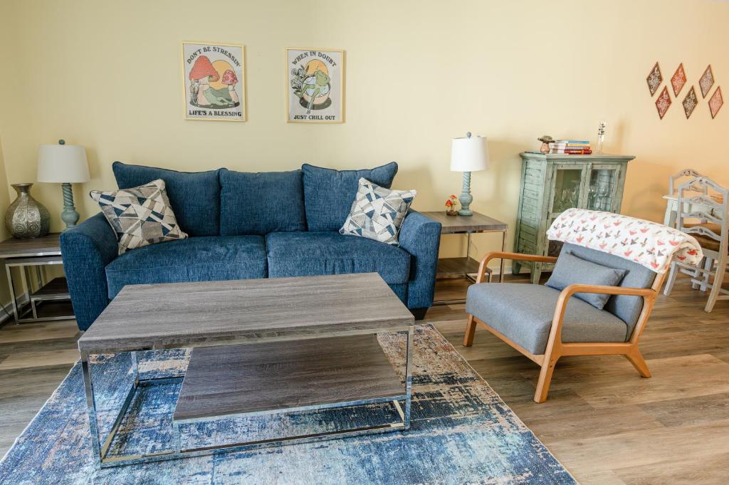 sala de estar con sofá azul y silla en Portabella Paradise, en Carolina Beach