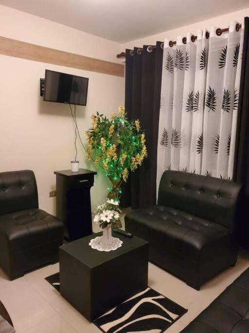 a living room with two chairs and a vase of flowers at Apartamentos La Floresta in Cochabamba