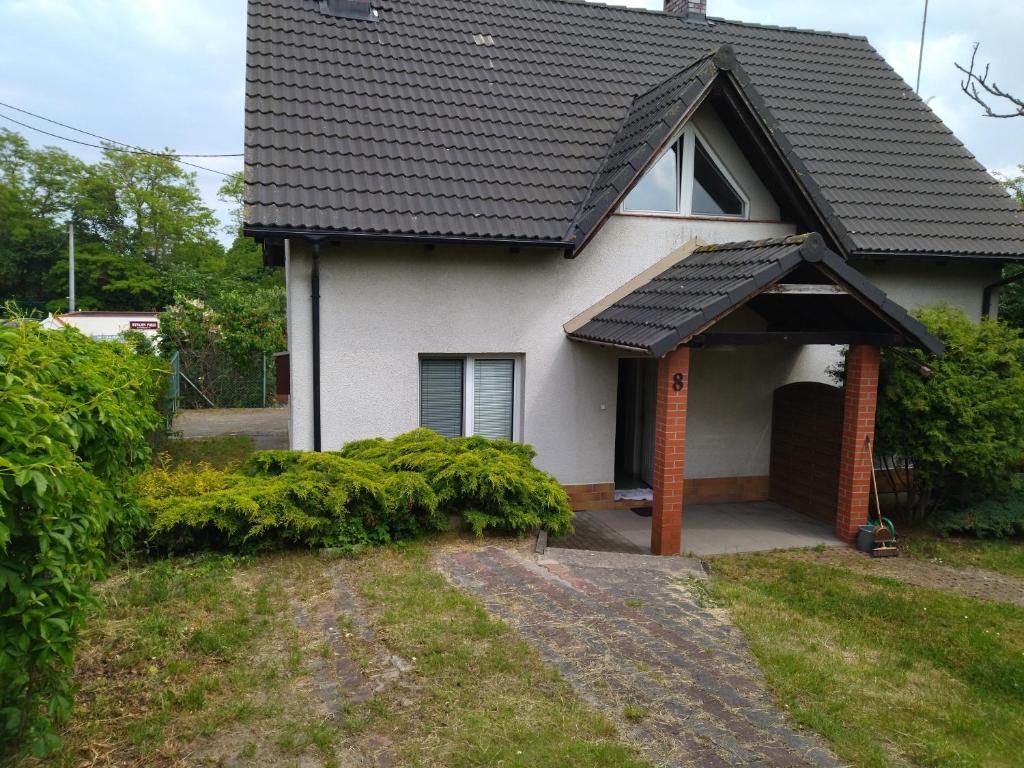 uma casa branca com um telhado preto em Dom na Cichej em Krynica Morska