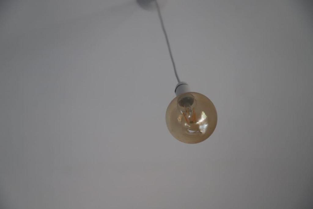 a donut hanging from a string on a white wall at Raviya Place in Dickwella