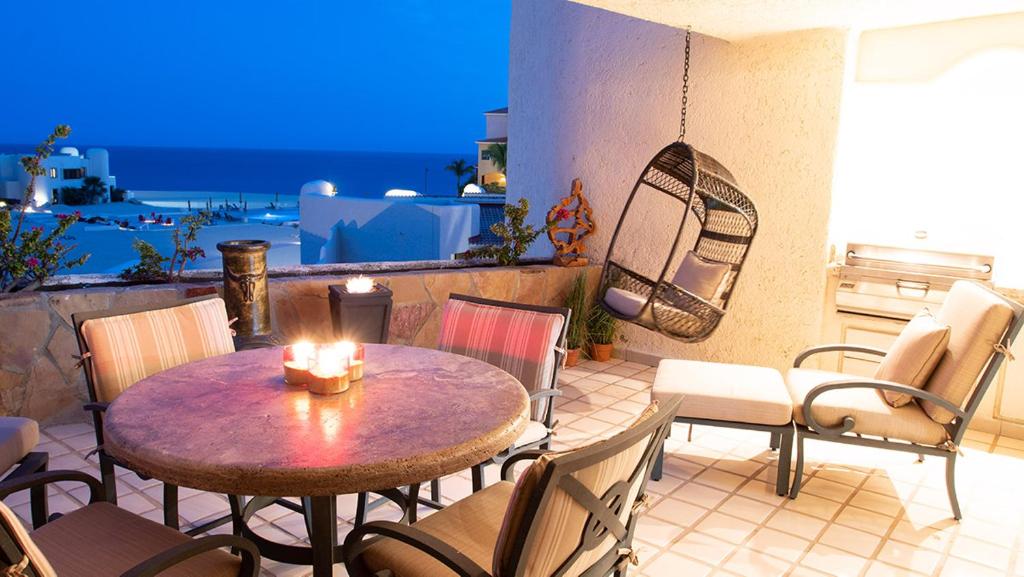 a patio with a table and chairs on a balcony at Terrasol Elite Premium Vacation Rentals in Cabo San Lucas