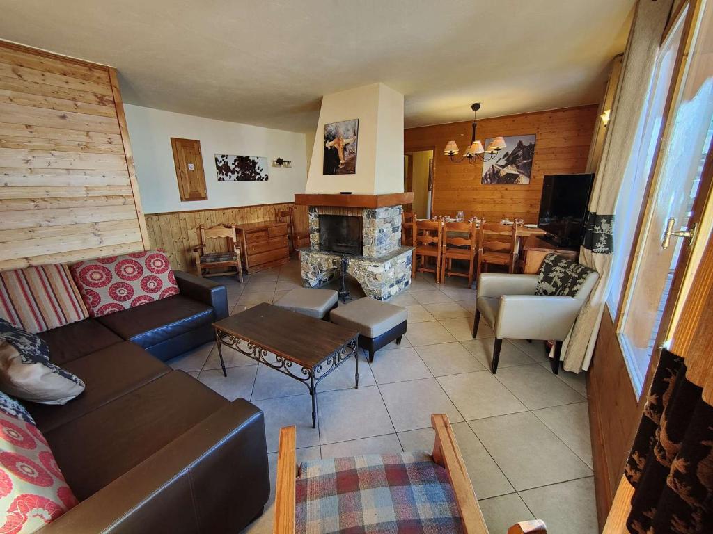 un salon avec un canapé et une cheminée dans l'établissement Chalet confortable à Val Thorens, 50m des pistes, 8 pers., cheminée, parking, local à skis - FR-1-637-80, à Val Thorens