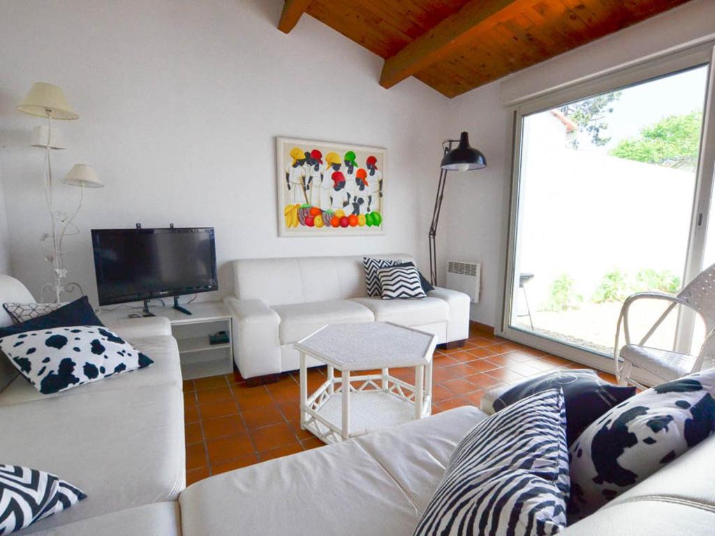 un salon avec un canapé blanc et une télévision dans l'établissement Villa 3 Pièces avec WIFI, Animaux Admis, Parking à La Palmyre - FR-1-705-59, aux Mathes