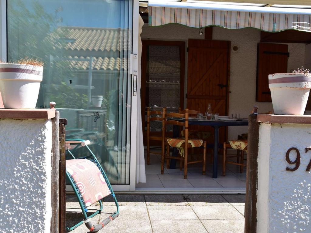 un patio avec une table et des chaises sur un porche dans l'établissement Maison familiale climatisée 4 pièces, 6 couchages, à 100m de la plage - Gruissan Les Ayguades - FR-1-229-878, à Gruissan