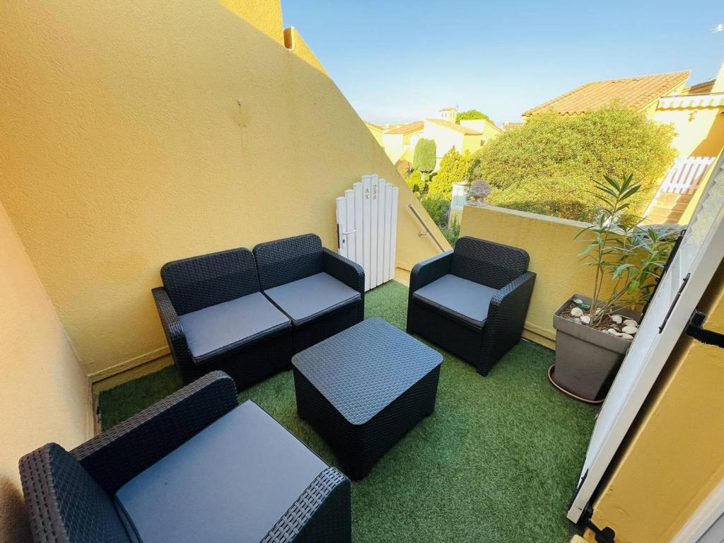 d'un balcon avec des canapés et des chaises sur la terrasse. dans l'établissement Studio avec Mezzanine, Terrasse et Parking à 5 min de la Plage - FR-1-723-129, au Cap d'Agde