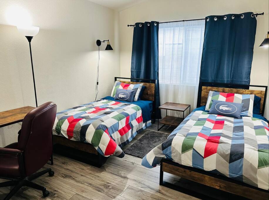 een slaapkamer met twee bedden, een bureau en een stoel bij Sweet Holiday in Antelope