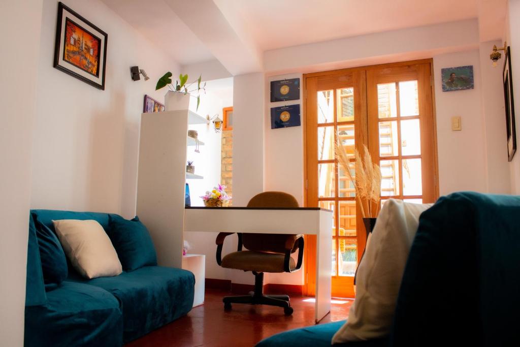 a living room with a blue couch and a desk at Yoly's House in Caraz